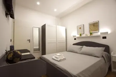 a white bedroom with a bed with a mirror and a mirror at Milizie Holiday House in Rome