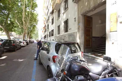 a car and a motorcycle parked on the side of a street at Milizie Holiday House in Rome