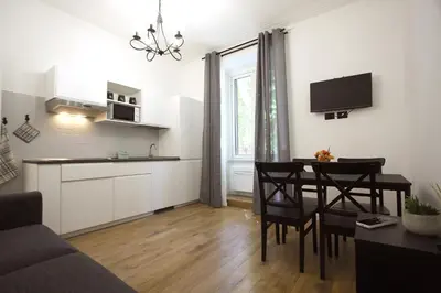 a living room with a kitchen and a dining room at Milizie Holiday House in Rome