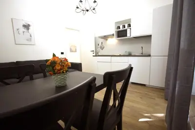 a kitchen and a table with a vase of flowers on it at Milizie Holiday House in Rome