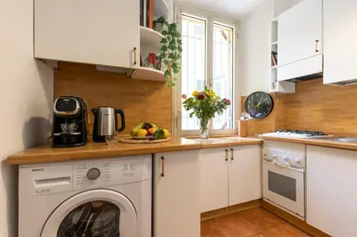 a white kitchen with a washing machine in it at Rome As You Feel - Cozy Open Space Near the Vatican in Rome