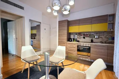 a kitchen with a glass table and white chairs at Enchanting Garden Retreat in Rome