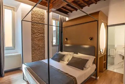 a bedroom with a canopy bed in a room at Ora Acanfora Suites in Rome