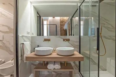 a bathroom with two sinks and a mirror at Ora Acanfora Suites in Rome