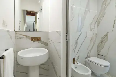 a white bathroom with a sink and a toilet at Ora Acanfora Suites in Rome