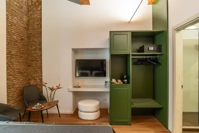 a living room with a green cabinet and a tv at Ora Acanfora Suites in Rome