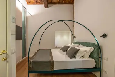 a bedroom with a bed with an arched frame at Ora Acanfora Suites in Rome