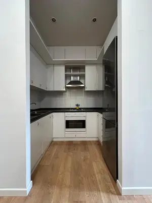 a kitchen with white cabinets and stainless steel appliances at Cozy apartment- 100 meters from Vatican in Rome