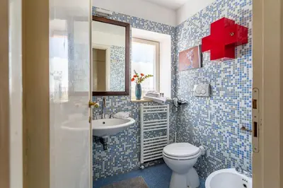a blue tiled bathroom with a toilet and a sink at iFlat Peaceful apt with terrace next to Vatican in Rome