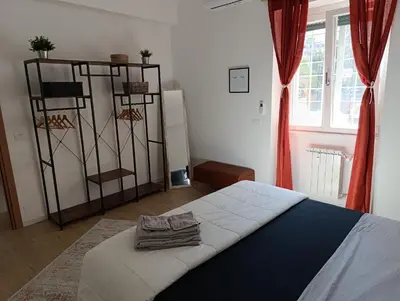 a bedroom with a bed and a window with red curtains at Think House in Rome