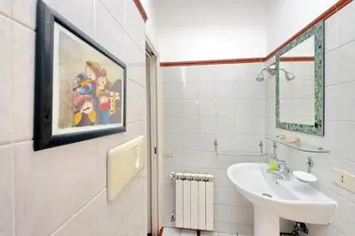 a bathroom with a sink and a painting on the wall at Cappellari37 in Rome