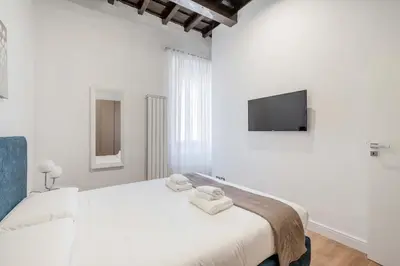 a white bedroom with a bed with towels on it at Rufina's Home in Rome