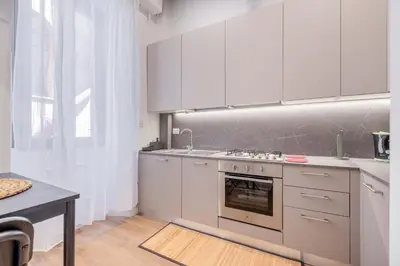 a kitchen with white cabinets and a stove top oven at Rufina's Home in Rome