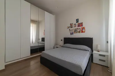 a white bedroom with a bed and a mirror at GuestHost - Regina Margherita Suite in Rome