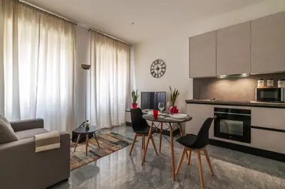 a kitchen and living room with a table and chairs at GuestHost - Regina Margherita Suite in Rome