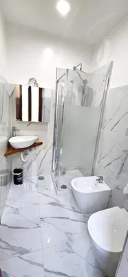 a white bathroom with a toilet and a sink at VATICAN ERA Guest House in Rome