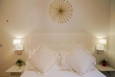 a bedroom with a bed with white pillows and a mirror at Bruno Domus Design in Rome
