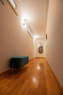 a room with a green ottoman on a wooden floor at Bruno Domus Design in Rome