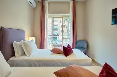 a hotel room with two beds and a window at Vatican Pop House in Rome