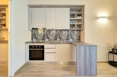 a kitchen with white cabinets and a counter top at Vatican Pop House in Rome