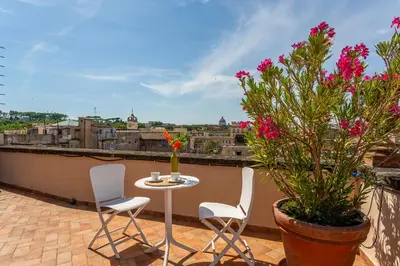 a patio with a table and chairs on a balcony at iFlat Campo de' Fiori Panoramic Penthouse in Rome