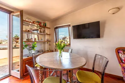 a dining room with a table and chairs and a tv at iFlat Campo de' Fiori Panoramic Penthouse in Rome