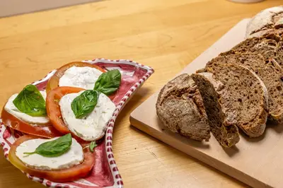 a loaf of bread and a cutting board with a sandwich at iFlat Spanish Steps Peaceful Apartment in Rome
