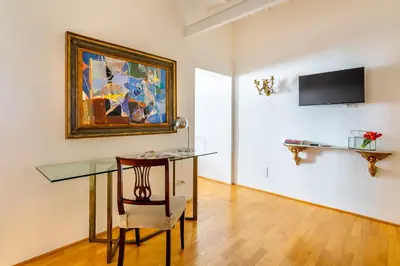 a dining room with a glass table and a painting at iFlat Spanish Steps Peaceful Apartment in Rome