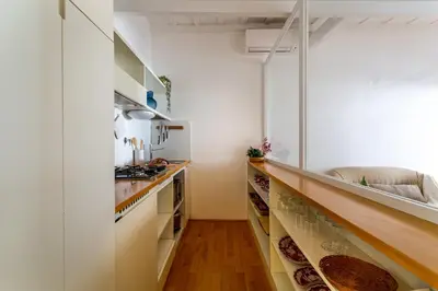 a kitchen with white walls and a long counter at iFlat Spanish Steps Peaceful Apartment in Rome