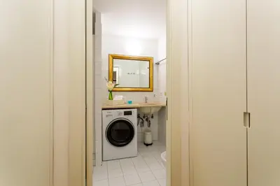 a bathroom with a washing machine and a mirror at iFlat Spanish Steps Peaceful Apartment in Rome