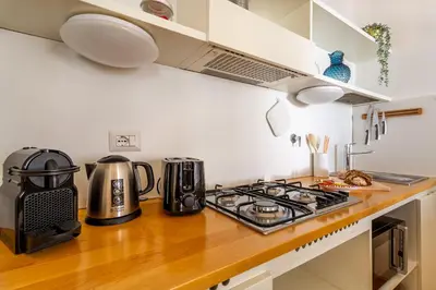 a kitchen counter with a stove top oven next to a stove at iFlat Spanish Steps Peaceful Apartment in Rome
