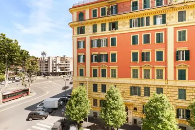 a tall orange building with cars parked next to a street at Clodio Welcome - 5 camere arredate con bagno interno - zona comune - condizionatori - in Rome