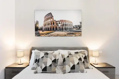 a bedroom with a bed with a picture of the coliseum at Clodio Welcome - 5 camere arredate con bagno interno - zona comune - condizionatori - in Rome