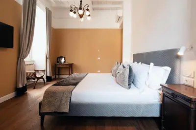 a bedroom with a bed and a chandelier at NAMAN HOTELLERIE - Monti in Rome