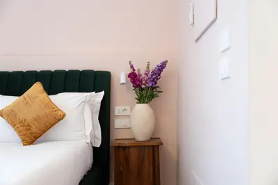a bedroom with a bed and a vase with purple flowers at NAMAN HOTELLERIE - Monti in Rome