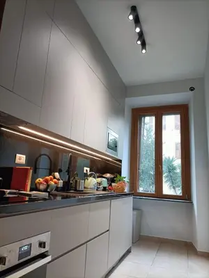 a kitchen with white cabinets and a window at Testaccio Bodoni apartment in Rome