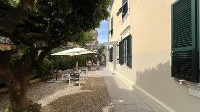 a patio with a table and chairs and a tree at Holiday Garden House Roma in Rome