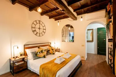 a bedroom with a large bed with a clock on the wall at Studio Campo de' Fiori in Rome