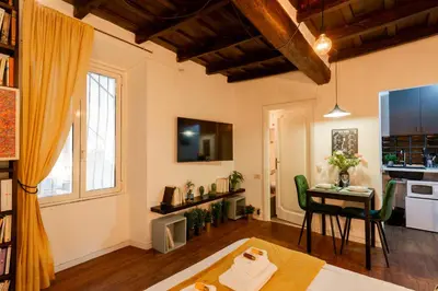 a living room with a table and a kitchen at Studio Campo de' Fiori in Rome