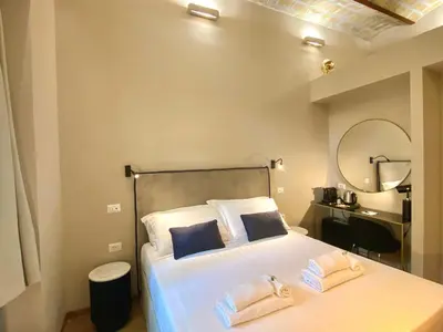 a bedroom with a bed with two pillows and a mirror at Queen of Rome Luxury Rooms in Rome