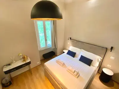 a bedroom with a bed with a black lamp above it at Queen of Rome Luxury Rooms in Rome