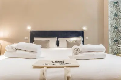 a large white bed with towels on top of it at Queen of Rome Luxury Rooms in Rome