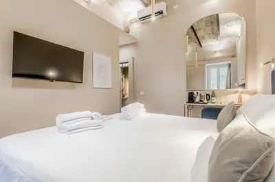 a bedroom with a white bed with towels on it at Queen of Rome Luxury Rooms in Rome