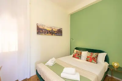 a small bedroom with a bed with a green headboard at Appartamento Vatican Terrace in Rome