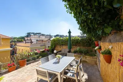 a table and chairs on a patio with flowers at Appartamento Vatican Terrace in Rome