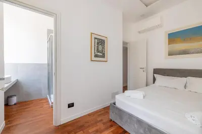 a bedroom with a white bed and a large mirror at Cavour 211 - B&D Apartments in Rome