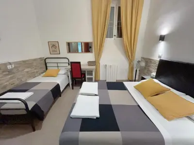 a room with two beds and a table and chairs at Overseas Guesthouse in Rome
