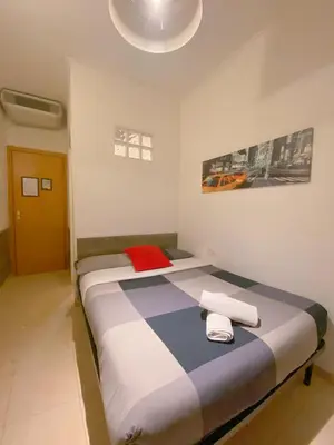 a bedroom with a large bed with two towels on it at Overseas Guesthouse in Rome