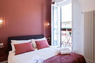 a bedroom with a bed with red walls and a window at LV Vatican boutique apartment in Rome