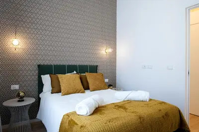 a bedroom with a bed with gold and white pillows at LV Vatican boutique apartment in Rome